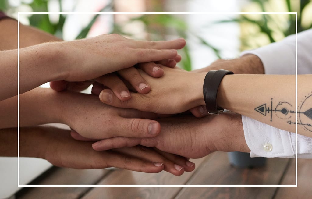 Managed IT Services for Omaha Businesses 9 Team members placing their hands together in a gesture of collaboration and trust, representing a partnership-focused approach to managed IT services and long-term planning.